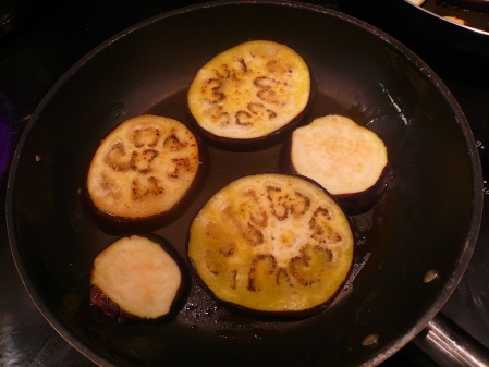Frying the eggplant slices in olive oil.